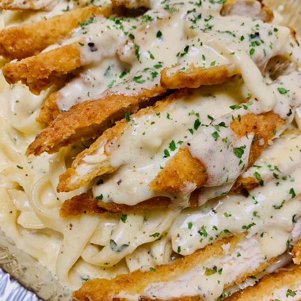 Creamy pasta with crispy breaded chicken strips and parsley, a dish from Fat Moe's Pizza & Wings.