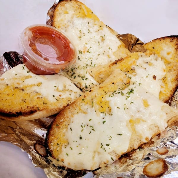 Cheesy garlic bread from Fat Moe's Pizza & Wings, with a side of marinara sauce.